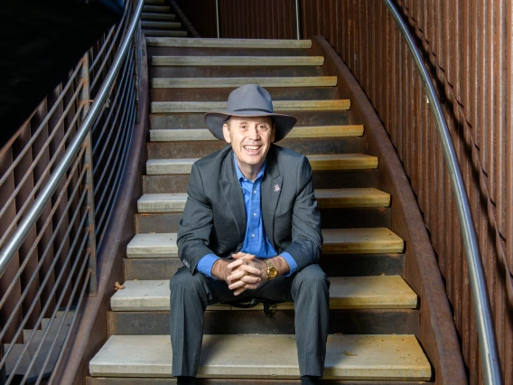 Dean Shane Burgess sits at the bottom of a metal staircase in the ENR2 building on the University of Arizona main campus