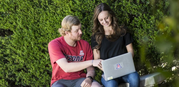 Student helping another student on their computer