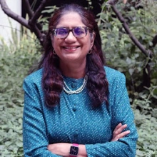 Headshot of Sadhana Ravishankar amid the natural courtyard at the ENR2 building on UA main campus