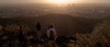 a group of students stands atop a mountain at sunset looking down over the Tucson valley